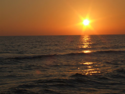 The sky turns a deep orange as the sun sinks into the horizon of the Gulf of Mexico in Panama City Beach, FL. The sky turns a deep orange as the sun sinks into the horizon of the Gulf of Mexico in Panama City Beach, FL.